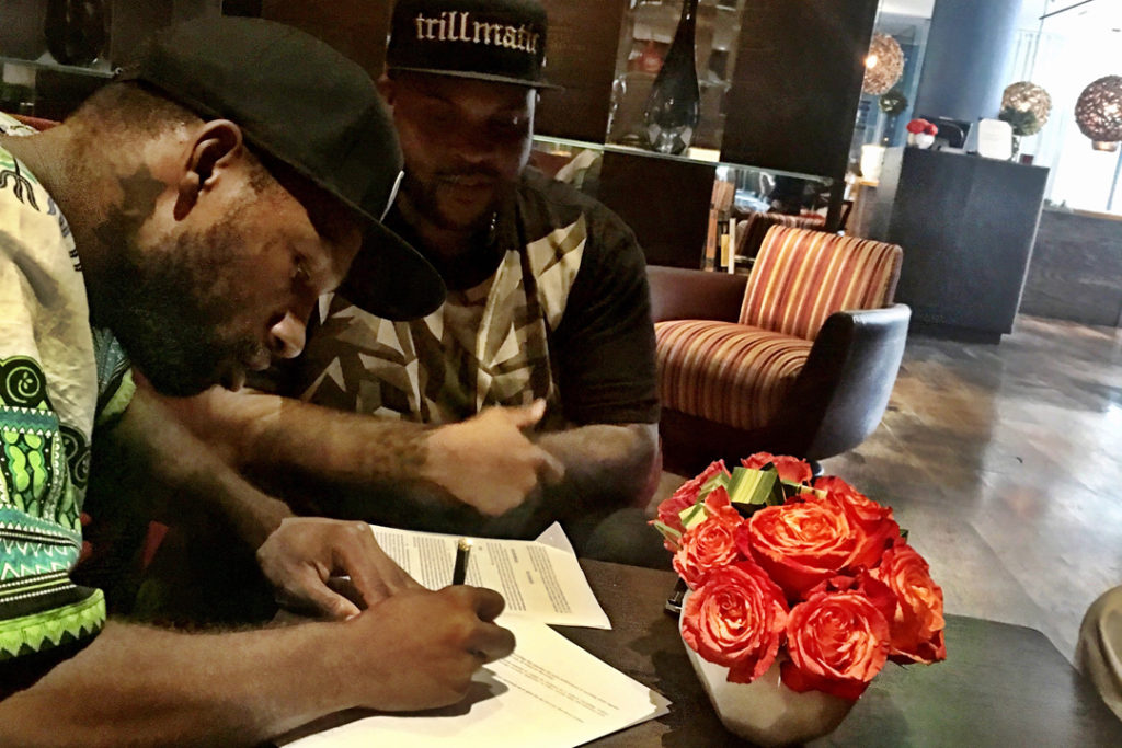 Isa Muhammad signing MMG contract. Courtesy of Complex Mag